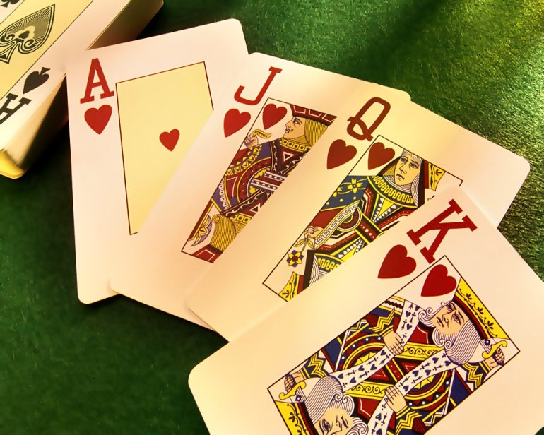 Una baraja de cartas sobre la mesa en el casino, por separado se encuentran ACE, Jack, Reina y rey