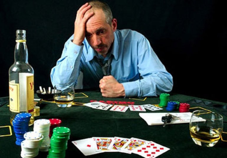 un jugador en la mesa con cartas y una botella